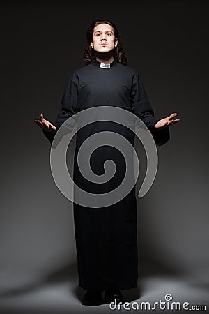 Young priest is praying Stock Photo