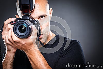 Young, pro male photographer in his studio during a photo shoot Stock Photo