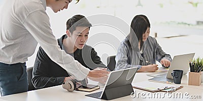 Young professional businessman explaining his idea to his team members in the meeting room Stock Photo