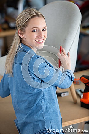 young professional decorator during upholstery armchair Stock Photo