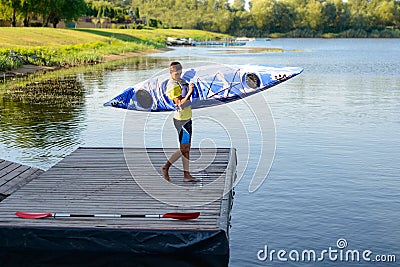 Young Professional Kayaker Getting Ready for Morning Kayak Training on River. Sport and Active Lifestyle Concept Stock Photo