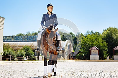 Young promising equestrian training on big spacious race track Stock Photo