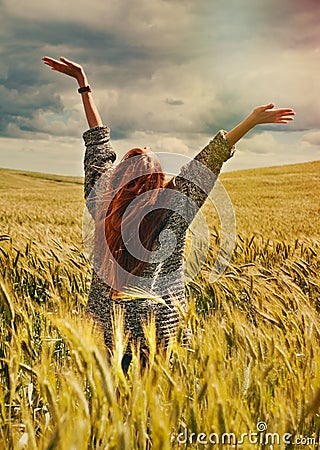 Young red hair woman standing back hands up to breathtaking view Stock Photo