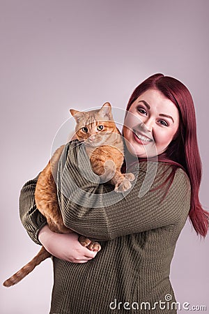 Woman holding cute male orange tabby cat smiling Stock Photo