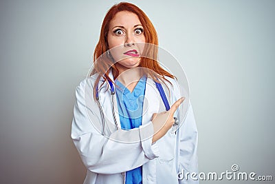 Young redhead doctor woman using stethoscope over white isolated background Pointing aside worried and nervous with forefinger, Stock Photo