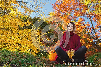 Young redhead girl in red clothes sitting on stair Stock Photo