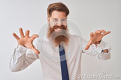 Young redhead irish businessman standing over isolated white background smiling funny doing claw gesture as cat, aggressive and Stock Photo