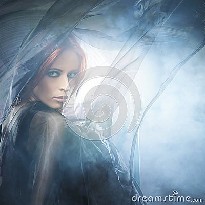 A young redhead woman in blue and red silk clothes Stock Photo