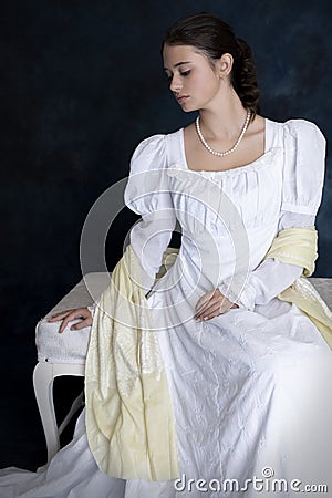 A young Regency woman wearing a white muslin dress and a pearl necklace Stock Photo