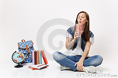 Young relaxed woman student with closed eyes hold plastic cup of soda or cola drinking sit near globe, backpack, school Stock Photo