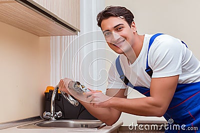 The young repairman working at the kitchen Stock Photo