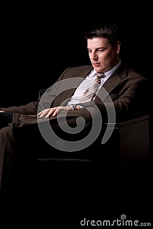 Young rich businessman sitting in armchair Stock Photo