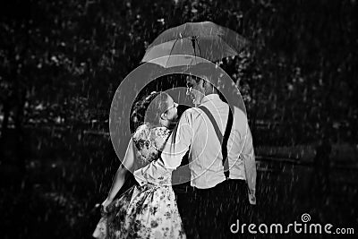 Young romantic couple in love flirting in rain. Black and white Stock Photo