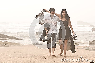 Young romantic couple walking along beach Stock Photo