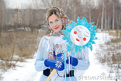 Young Russian woman in a shawl and blue mittens in a winter park. Portrait, close up Stock Photo