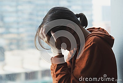 Young sad depressed frustrated woman sitting at home alone suffering and crying Stock Photo