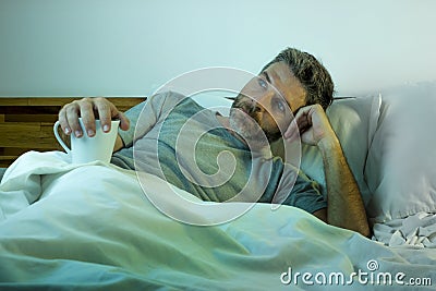 Young sad and depressed man lying thoughtful and pensive on bed looking away feeling lost thinking suffering some problem in Stock Photo