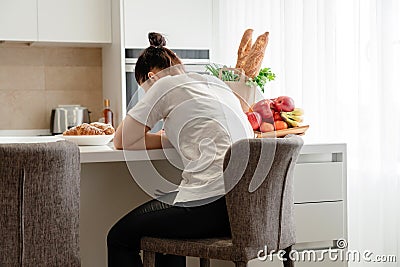 Young sad woman suffering in kitchen, Stressed housewife in kitchen Stock Photo