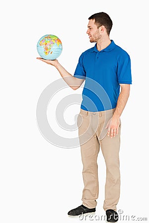 Young salesman holding globe in his palm Stock Photo