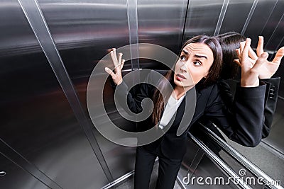 young scared businesswoman suffering from claustrophobia in elevator. Stock Photo
