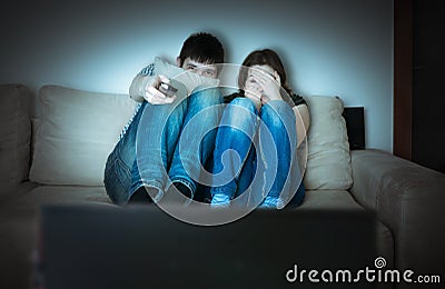 Young scared couple is watching horror on TV Stock Photo