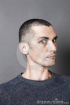 Young scary man acting superior, expressing suspicion and unhappiness Stock Photo