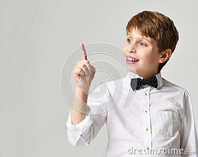 Young school boy in white shirt pointing finger up close up composition on gray Stock Photo