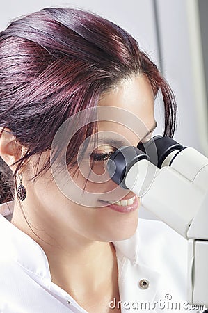 Young scientist studying new substance or virus with microscope Stock Photo