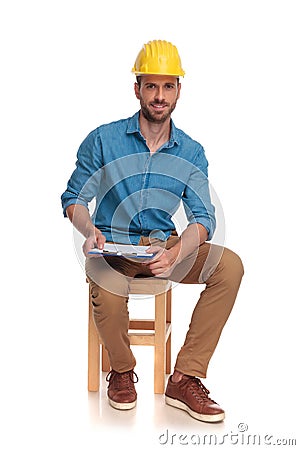Young seated construction engineer with clipboard Stock Photo