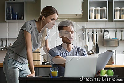 Young serious couple discussing domestic bills with papers and l Stock Photo