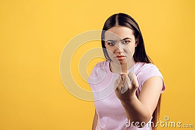 Young serious girl threatens with fist. Stock Photo