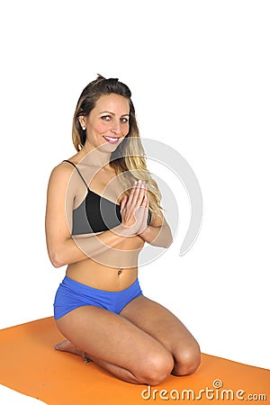 Young attractive fit woman at gym doing yoga exercise and position sitting on mat in meditation and relax Stock Photo