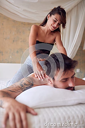 Young sexy girl giving massage to her boyfriend Stock Photo