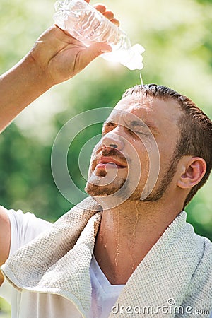 Young male athlete is refreshing himself with water Stock Photo