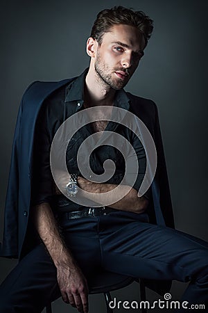 Young man in a classic suit sitting on a chair Stock Photo