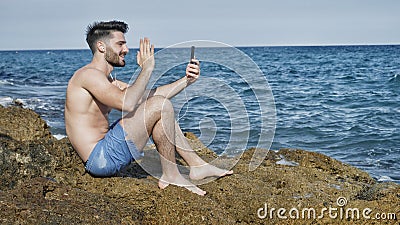 Handsome man doing videochat at sea Stock Photo