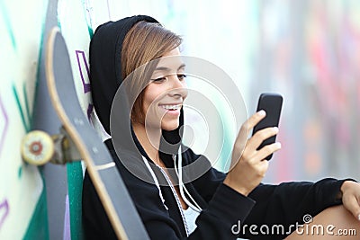 Young skater happy teen girl using a smart phone Stock Photo