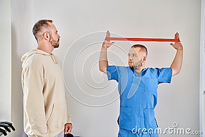 young skilled physiotherapist showing arm exercise Stock Photo