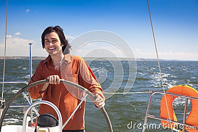 Young skipper driving sailboat Stock Photo