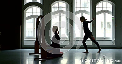 Young slender blonde girl dancer is in a large Studio with large Windows, she approaches the Gong with dancing movements Stock Photo