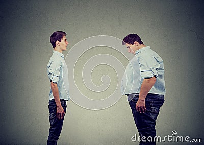 Young slim fit man looking at fat himself. Diet choice right nutrition healthy lifestyle Stock Photo