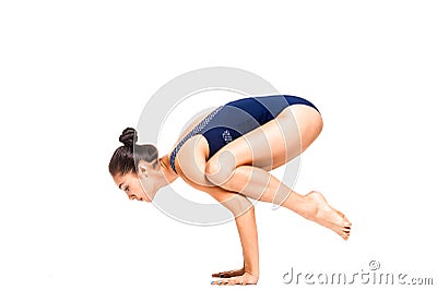 Young slim flexible woman doing arm balance yoga pose Stock Photo