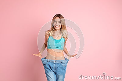 Young slim woman in old big jeans showing her Stock Photo