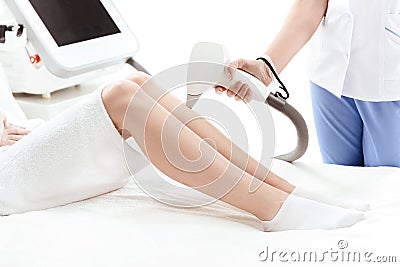 Young slim woman receiving laser skin care on leg Stock Photo