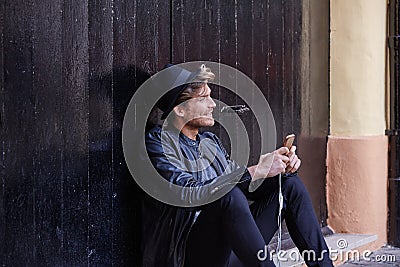 Young smartphone man sitting street Stock Photo