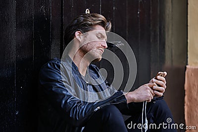 Young smartphone man sitting street Stock Photo