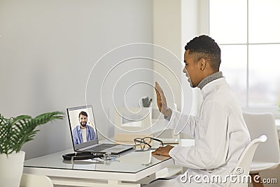Young smiling black man doctor therapist making online consultation Stock Photo