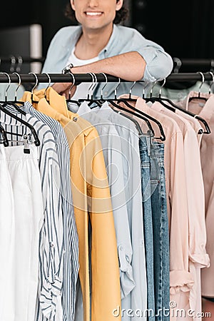 Young smiling boutique owner standing near clothes Stock Photo