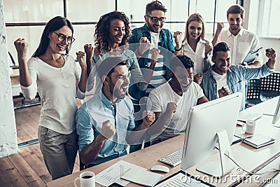 Young Smiling Business Team Celebrating in Office Stock Photo