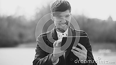 Young smiling businessman using tablet computer during break at the street Stock Photo